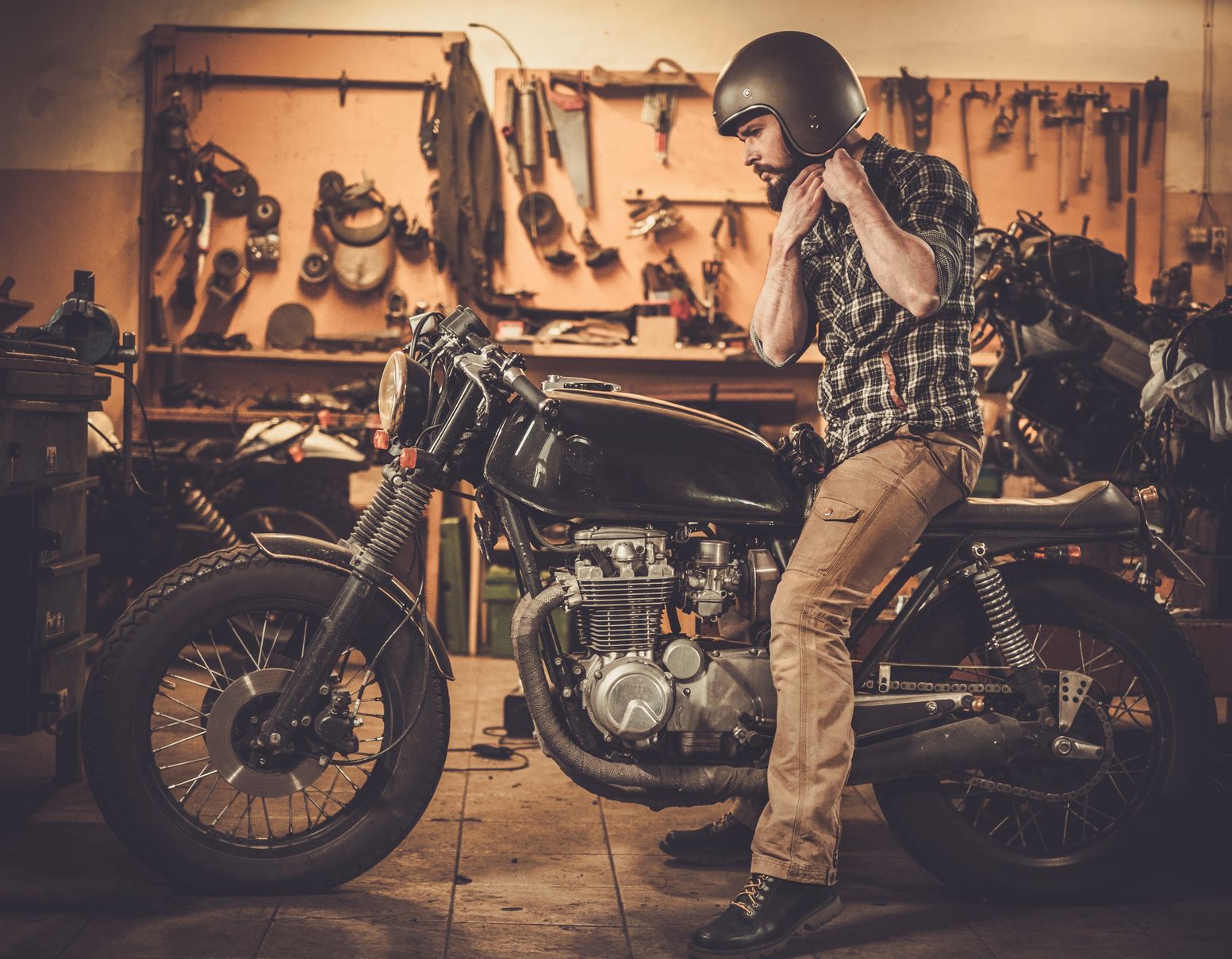 Rider And His Vintage Style Cafe Racer Motorcycle In Customs